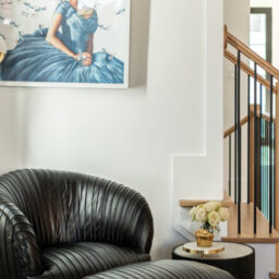 Chestnut black leather chair in corner with art piece custom furniture design and sphere floor lamp